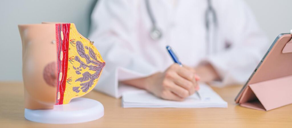 Mujer médica en consultorio con prototipo del seno para explicar procedimiento